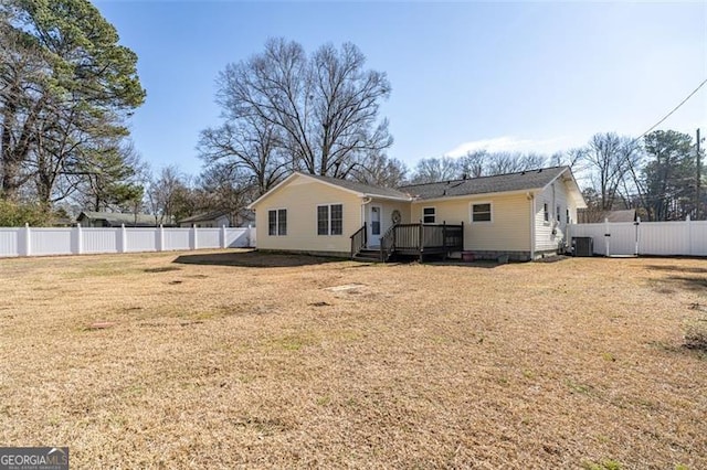 back of property with a wooden deck and a lawn