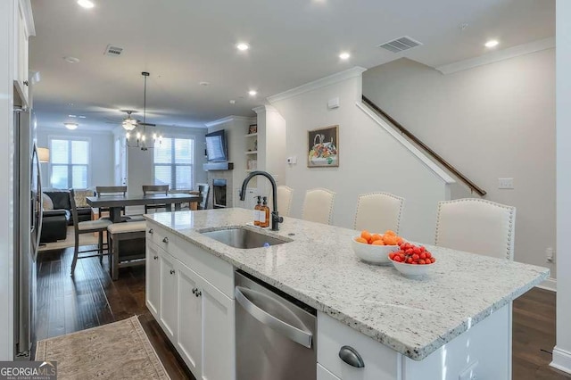 kitchen with white cabinetry, sink, stainless steel appliances, and an island with sink