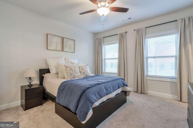 bedroom featuring light colored carpet and ceiling fan