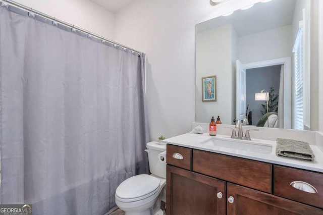 full bathroom featuring vanity, shower / bath combo with shower curtain, and toilet