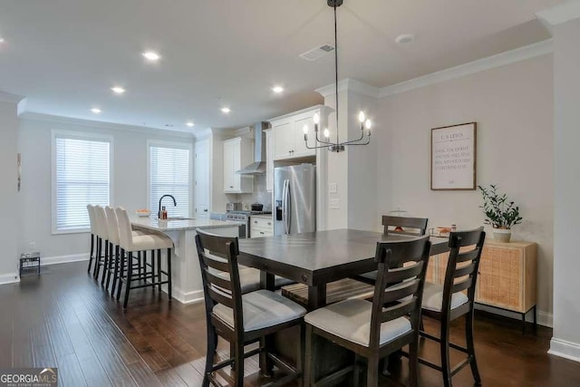 dining space with sink, dark wood-type flooring, and ornamental molding