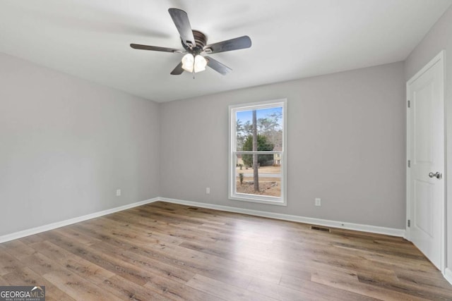 empty room with hardwood / wood-style flooring and ceiling fan