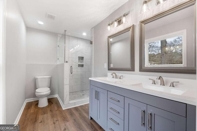 bathroom featuring hardwood / wood-style flooring, vanity, toilet, and an enclosed shower