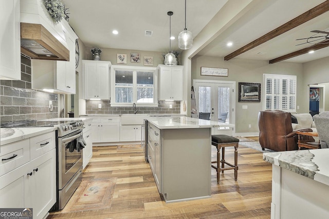 kitchen featuring white cabinetry, a kitchen island, and stainless steel range with electric cooktop