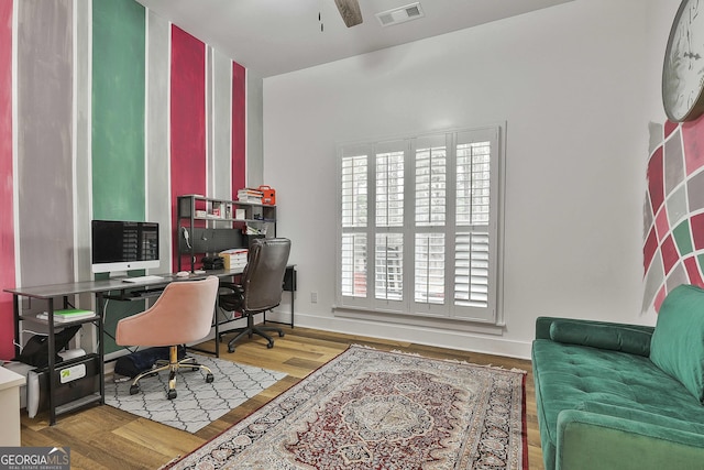 home office featuring wood-type flooring and ceiling fan