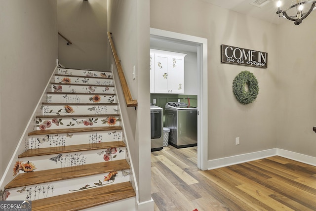 staircase with separate washer and dryer and hardwood / wood-style floors