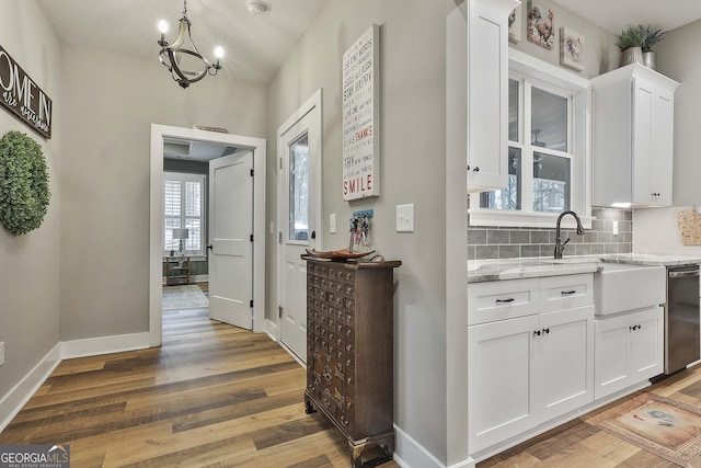 hallway with hardwood / wood-style floors, sink, and a chandelier