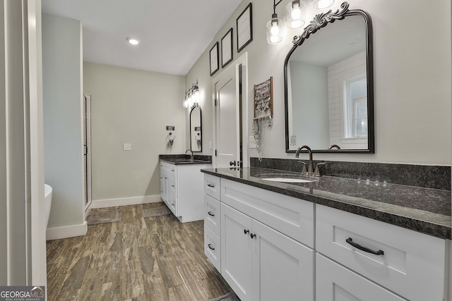 bathroom featuring vanity, wood-type flooring, and walk in shower