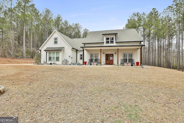 modern farmhouse style home with covered porch and a front lawn