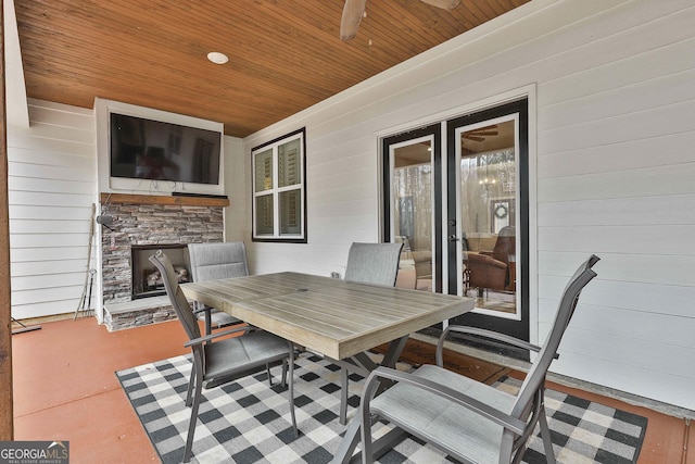 view of patio / terrace featuring ceiling fan and an outdoor stone fireplace