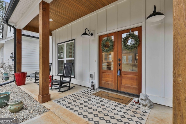 view of exterior entry with a porch and french doors