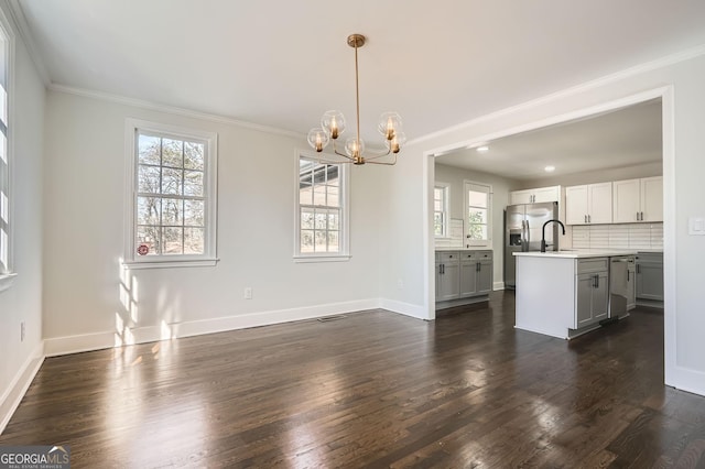 unfurnished dining area with ornamental molding, dark wood-type flooring, and a chandelier