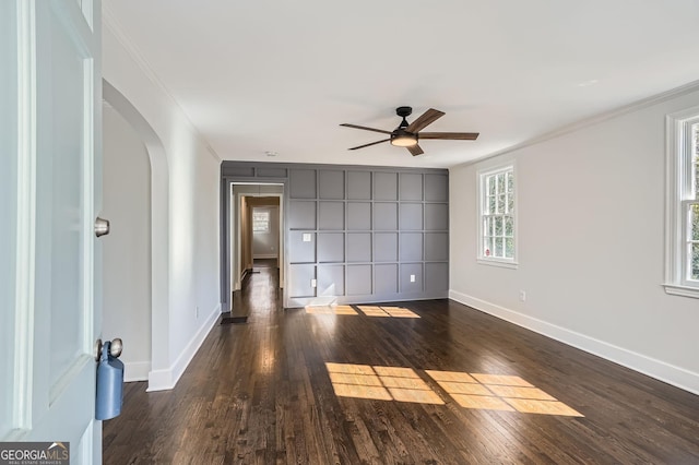 unfurnished room with ornamental molding, dark wood-type flooring, and ceiling fan