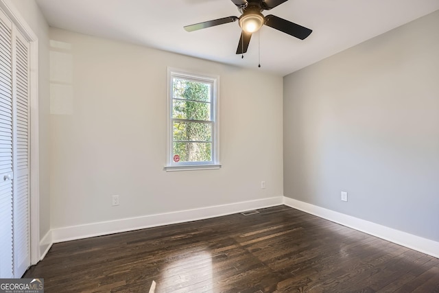 unfurnished bedroom with ceiling fan, dark hardwood / wood-style flooring, and a closet