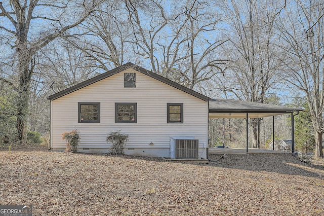 view of side of property with central AC and a carport