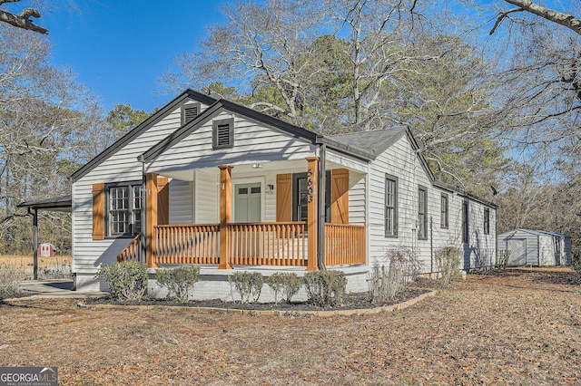 bungalow-style house with a storage shed and covered porch