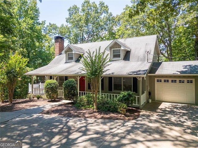 new england style home with a garage and covered porch