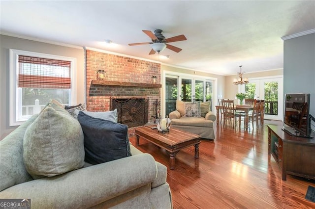 living room featuring french doors, crown molding, a brick fireplace, ceiling fan, and hardwood / wood-style floors