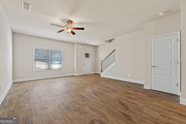 unfurnished living room featuring ceiling fan and dark hardwood / wood-style flooring