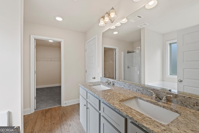 bathroom with hardwood / wood-style flooring, vanity, and separate shower and tub