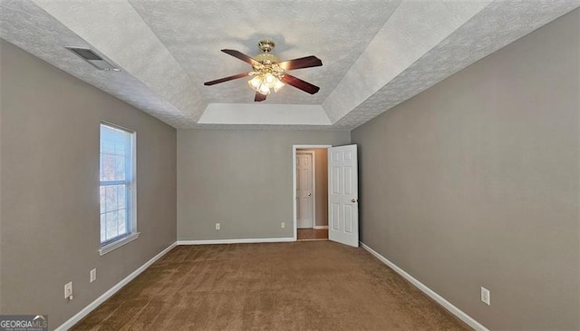 unfurnished bedroom with ceiling fan, carpet flooring, a raised ceiling, and a textured ceiling