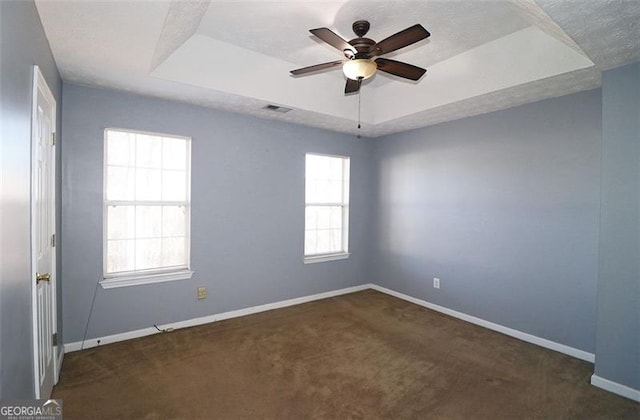 carpeted empty room with a tray ceiling, a textured ceiling, and ceiling fan