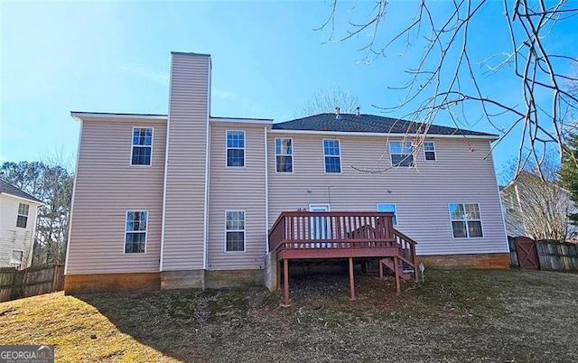 rear view of house with a deck and a lawn