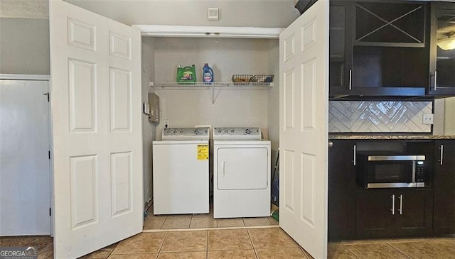 washroom featuring washing machine and clothes dryer and light tile patterned floors