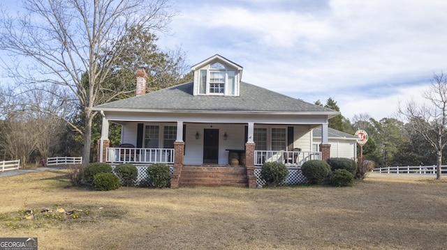 view of front facade featuring covered porch and a front yard