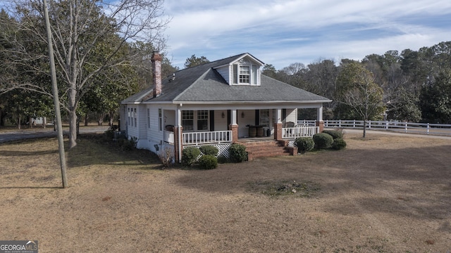 view of front of home with a porch and a front yard