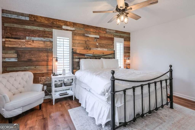 bedroom with hardwood / wood-style flooring, multiple windows, and wood walls