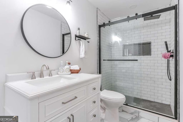 bathroom featuring vanity, toilet, and an enclosed shower