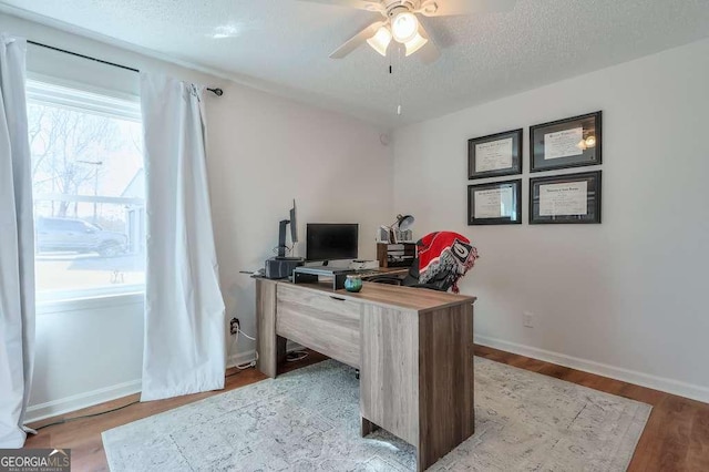 office area featuring ceiling fan, wood-type flooring, and a textured ceiling