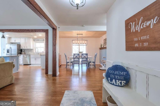 dining area featuring sink, hardwood / wood-style floors, and a chandelier