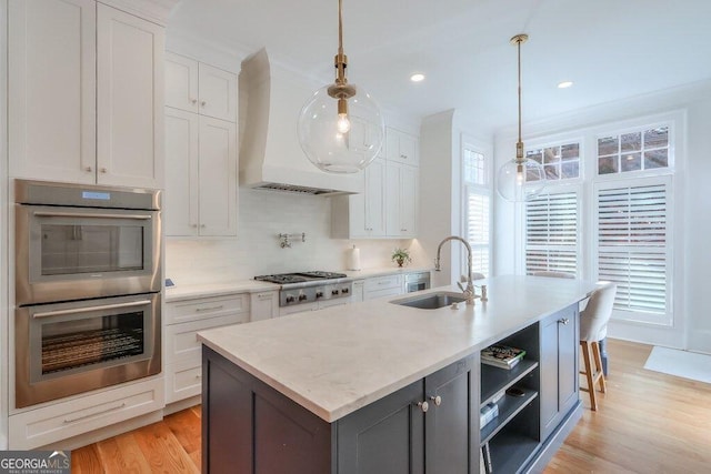 kitchen with stainless steel appliances, white cabinetry, sink, and pendant lighting