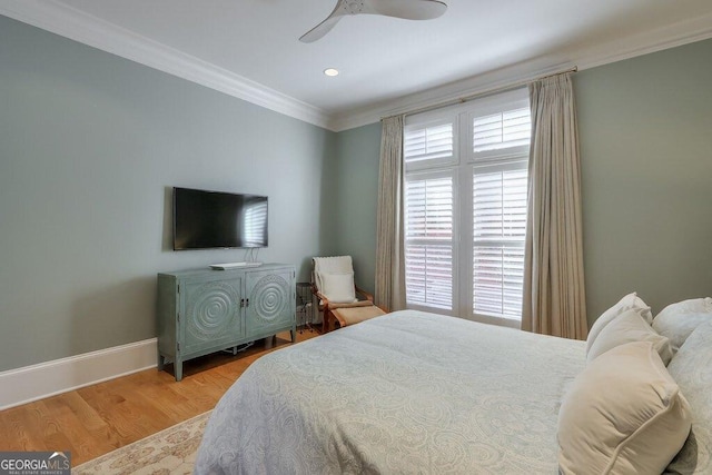 bedroom featuring multiple windows, ornamental molding, ceiling fan, and light wood-type flooring