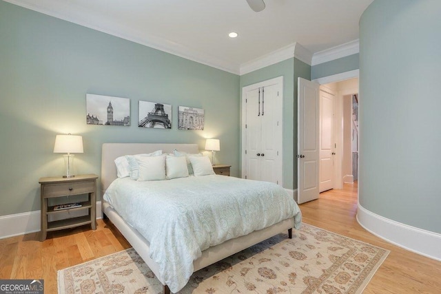 bedroom with ornamental molding, light hardwood / wood-style floors, and a closet