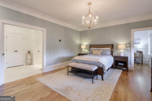 bedroom featuring hardwood / wood-style floors, crown molding, and a notable chandelier