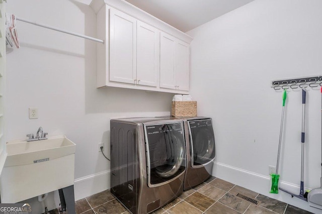 laundry room featuring cabinets, separate washer and dryer, and sink