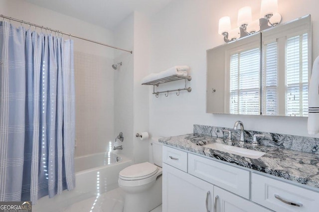 full bathroom with vanity, shower / tub combo with curtain, and toilet