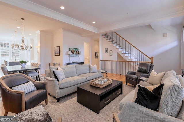 living room featuring an inviting chandelier, ornamental molding, and light hardwood / wood-style floors