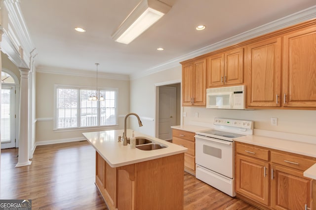 kitchen featuring sink, crown molding, hanging light fixtures, an island with sink, and white appliances