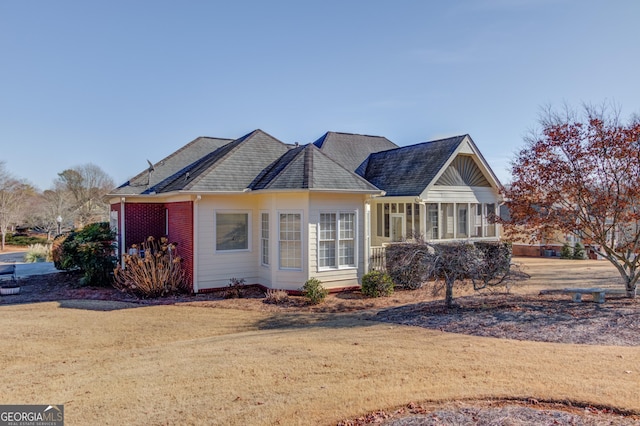 ranch-style home with a front yard and a sunroom