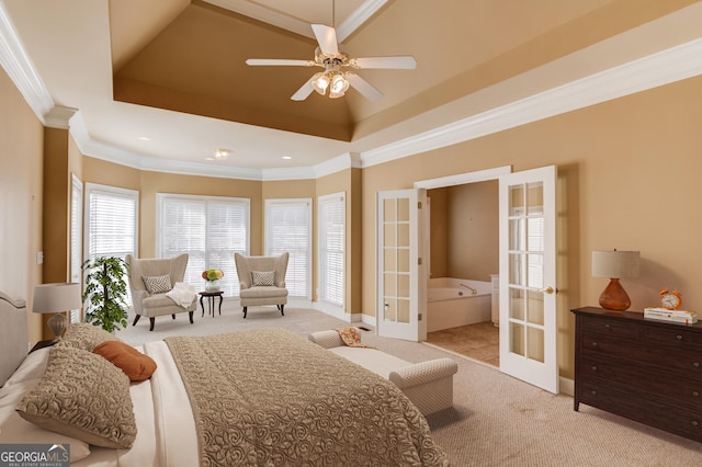 carpeted bedroom with ornamental molding, a tray ceiling, and french doors