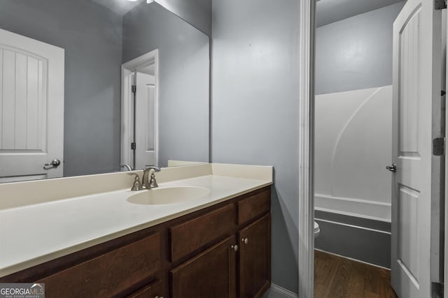 full bathroom featuring wood-type flooring,  shower combination, vanity, and toilet