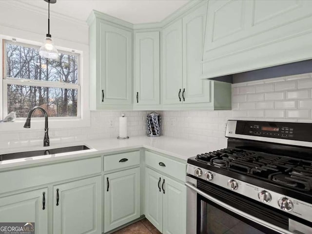 kitchen with backsplash, premium range hood, sink, and stainless steel gas range oven