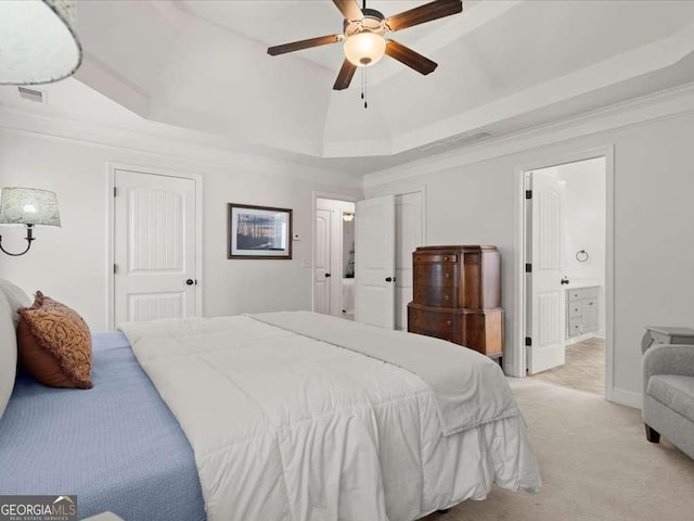 carpeted bedroom with ceiling fan, ornamental molding, connected bathroom, and a raised ceiling