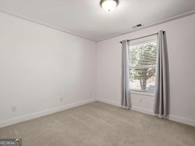 spare room featuring light carpet and crown molding