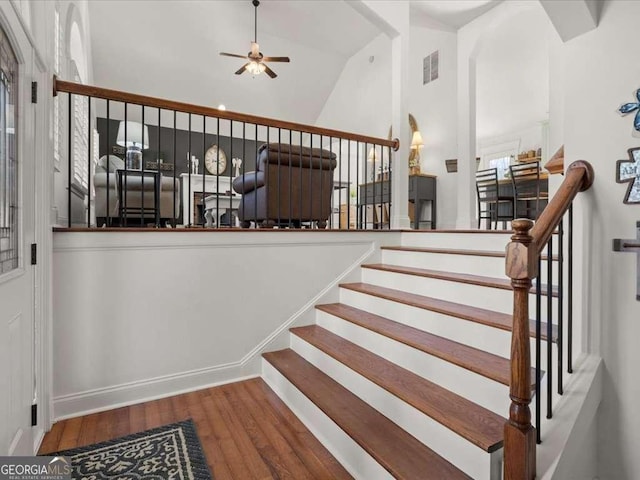 stairway featuring wood-type flooring, lofted ceiling, and ceiling fan