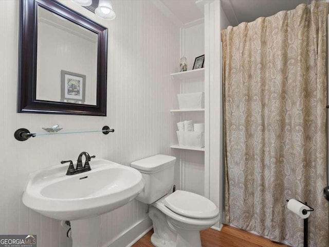 bathroom featuring sink, wood-type flooring, and toilet